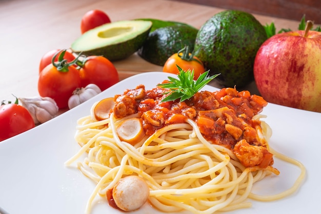 Spaghetti e pomodori freschi con condimenti su tavole di legno.