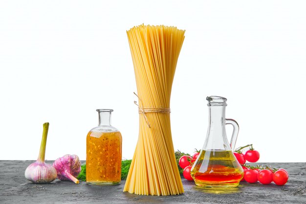 Spaghetti e verdure crudi sulla tavola di legno