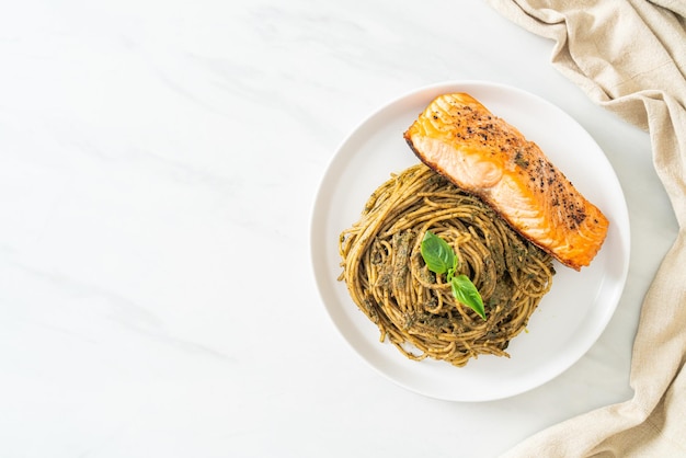 spaghetti fatti in casa al pesto con salmone alla griglia - stile alimentare italiano