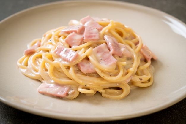 spaghetti fatti in casa con salsa di panna bianca con prosciutto - stile alimentare italiano