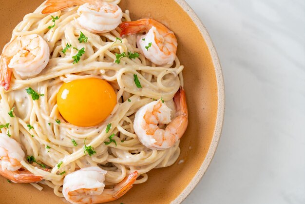 Spaghetti fatti in casa su crema bianca con gamberi e tuorlo d'uovo