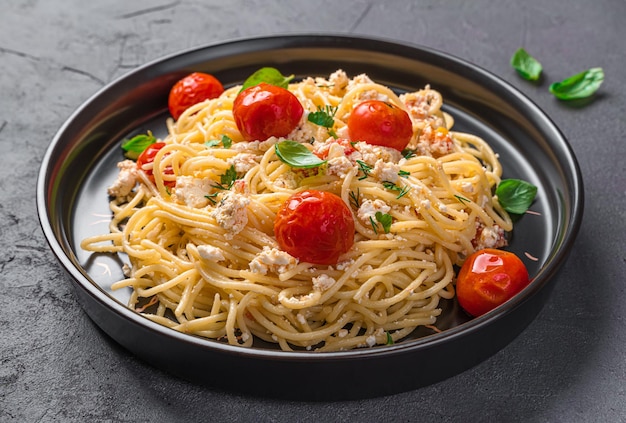 Spaghetti fetapasta con formaggio feta pomodorini ed erbe aromatiche primo piano Popolare pasta vegetariana con feta