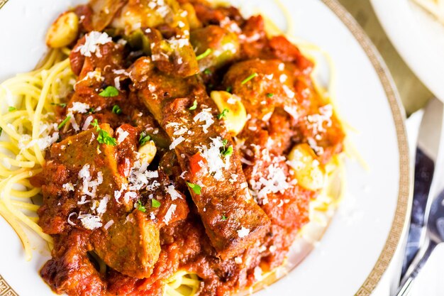 Spaghetti freschi con salsiccia, peperoni e cipolle nel ristorante italiano.