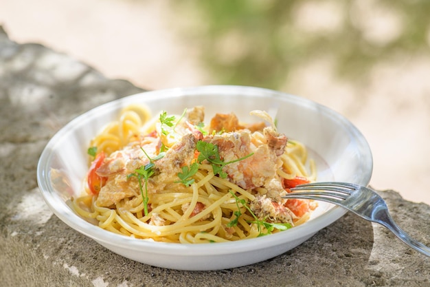 Spaghetti freschi cucinati con granchio di mare marrone commestibile noto anche come Cancer Pagurus dal Mar Mediterraneo su piatto bianco