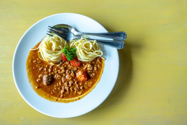 Spaghetti in salsa di pomodoro con carne di maiale e forchetta