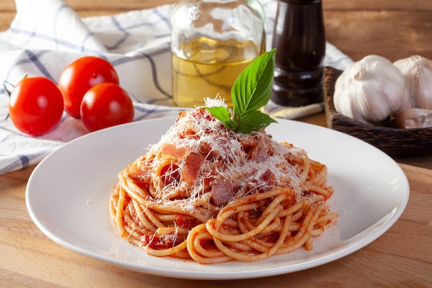 Spaghetti in un piatto su un fondo di legno