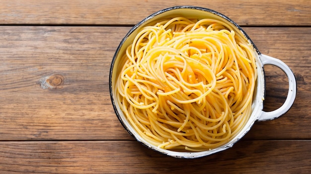 Spaghetti in un piatto su uno sfondo di legno