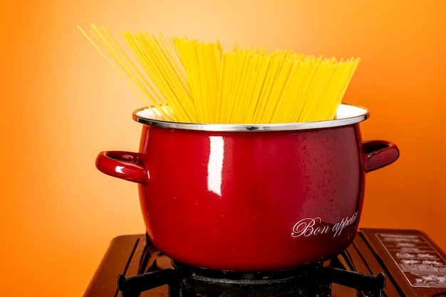 Spaghetti in una casseruola una bella casseruola rossa con gli spaghetti