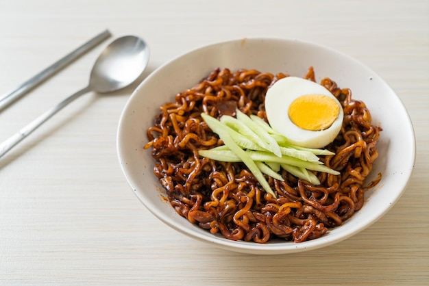 Spaghetti istantanei coreani con salsa di fagioli neri conditi con cetrioli e uova sode (Jajangmyeon o JJajangmyeon) - Stile alimentare coreano