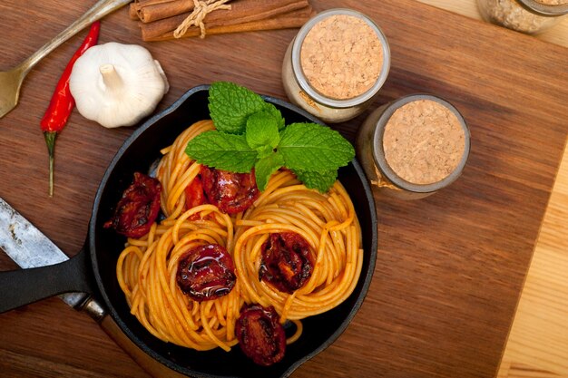 Spaghetti italiani e pomodoro con foglie di menta