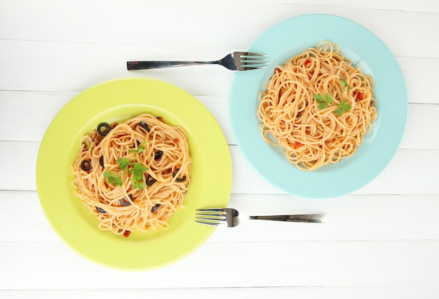 Spaghetti italiani in piatti sulla tavola di legno