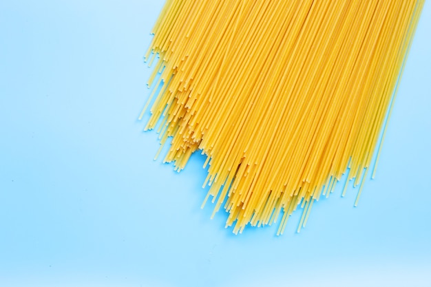 Spaghetti lunghi gialli su superficie blu