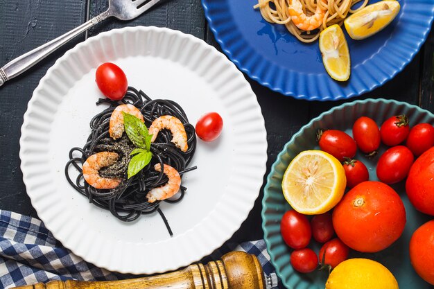 Spaghetti neri con gamberetti sul piatto bianco