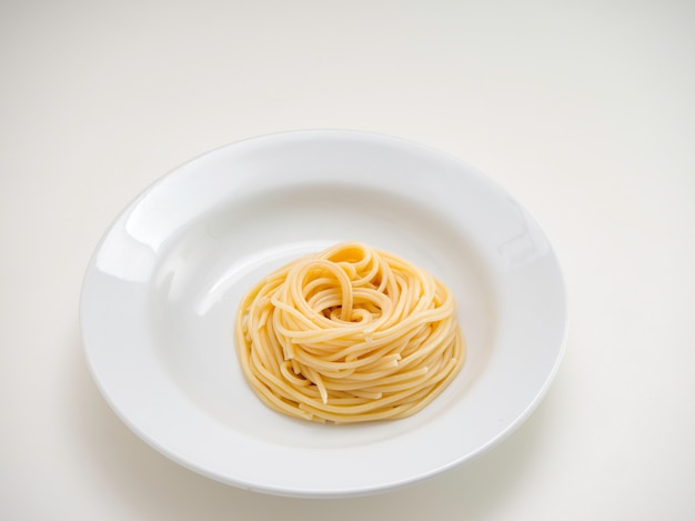 Spaghetti, pasta sul piatto su sfondo bianco