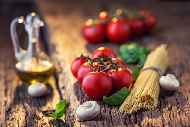 Spaghetti pomodoro basilico olio d'oliva parmigiano e funghi su tavola di quercia