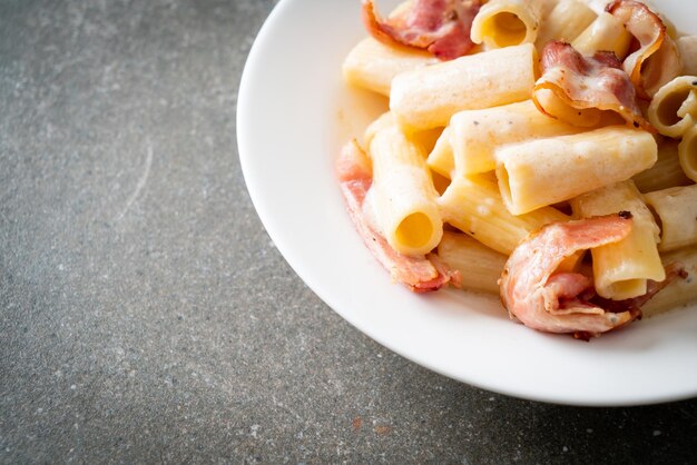 spaghetti rigatoni fatti in casa con salsa bianca e pancetta - stile alimentare italiano