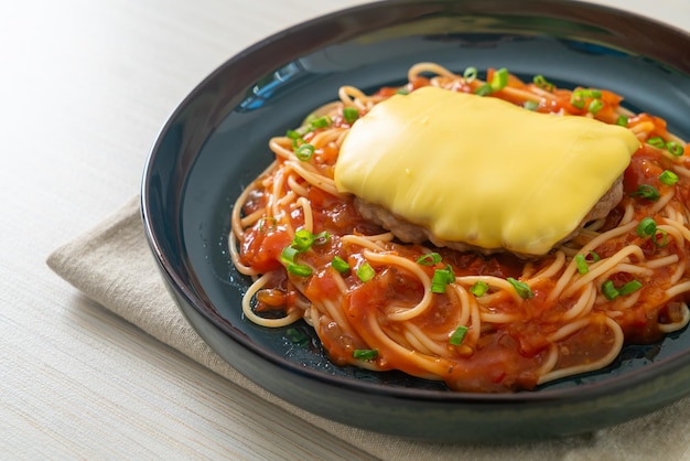 Spaghetti salsa di pomodoro con Amburgo e formaggio sul piatto