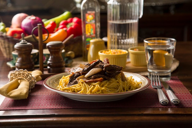 Spaghetti salsa huancaina e lomo saltado Perù peruviano comfort food mise en place tavola di legno