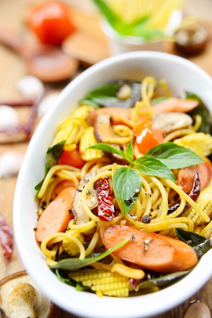 Spaghetti saltati in padella con peperoncino secco, erbe e salsiccia