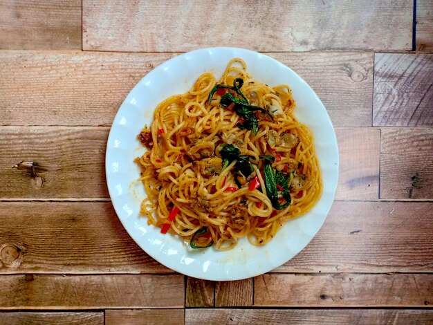 Spaghetti saltati in padella con vongole veraci su un tavolo di legno