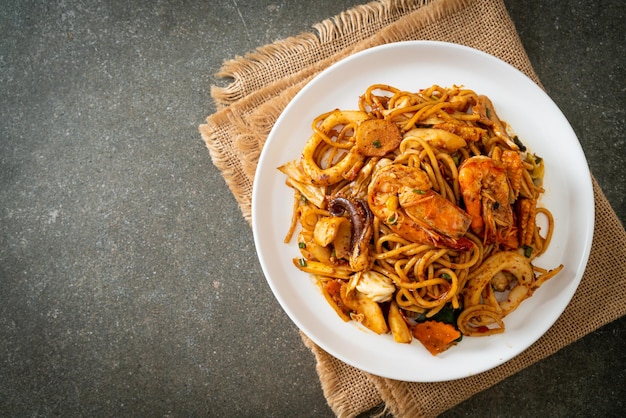 Spaghetti secchi ai frutti di mare Tom Yum saltati in padella - Stile cibo fusion