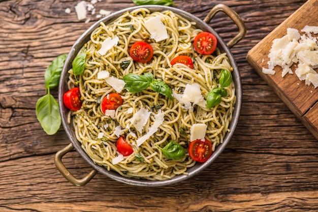 Spaghetti. Spaghetti di pasta italiana con pomodorini pesto di basilico e olio d'oliva.