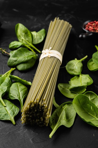 Spaghetti verdi secchi crudi con spinaci su sfondo nero tavolo in pietra scura