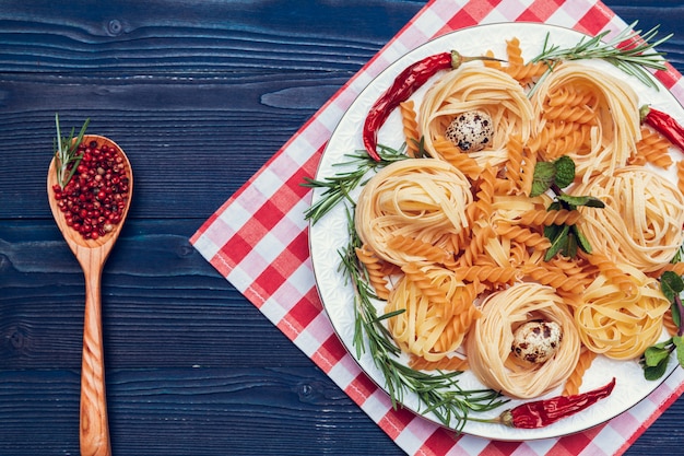 Spaghetti, verdure e spezie della pasta, sulla tavola di legno