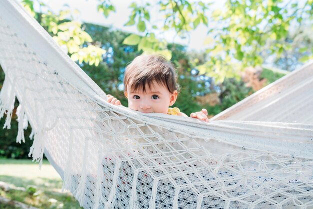 Spagna, bambina che si rilassa su un'amaca in giardino in estate