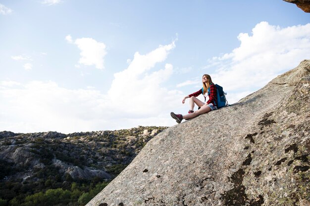 Spagna, Madrid, giovane donna che riposa su una roccia durante una giornata di trekking