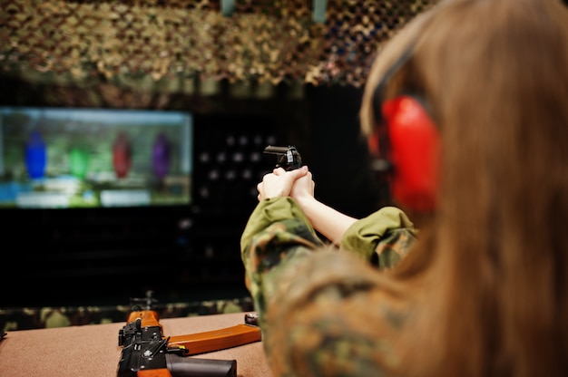 Sparare sul poligono di tiro. La donna sul poligono di tiro sparò dalla pistola.