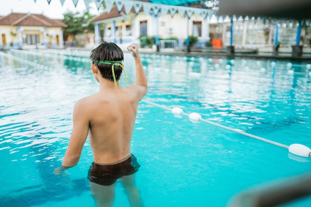 Sparato da dietro di un atleta maschio con il pugno chiuso in piscina dopo essere entrato al traguardo