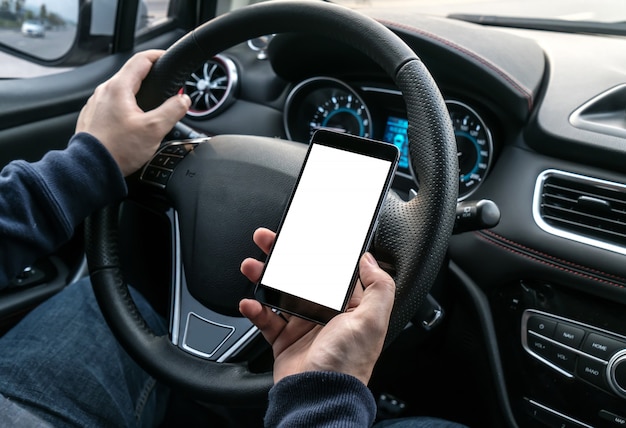 Sparato di un uomo bello che per mezzo del telefono cellulare mentre guidando.