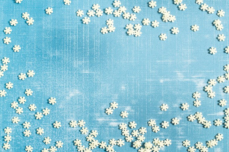 Foto spargimento di fiocchi di neve di zucchero su una superficie squallida strutturata azzurra con spazio per il testo