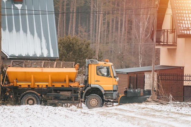 Spargisale che lavora sulla strada suburbana dopo abbondanti nevicate Neve che schiarisce le strade Spargimento di sale