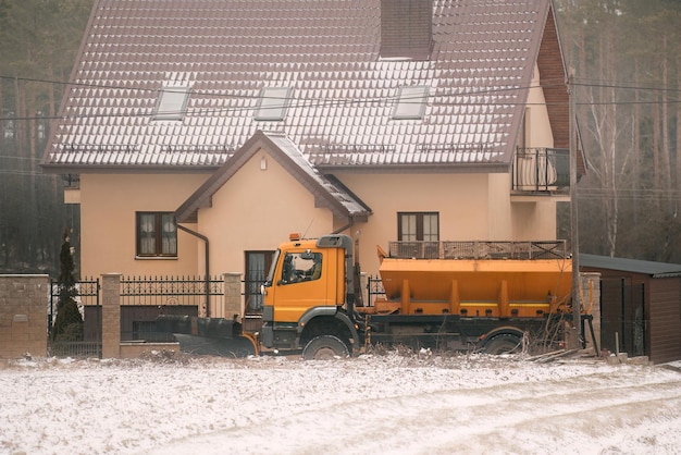 Spargisale che lavora sulla strada suburbana dopo abbondanti nevicate Sgombero della neve sulle strade Spargimento di sale