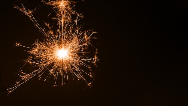 Sparkler colorato in fiamme, fuochi d'artificio su sfondo nero. Buon natale e felice anno nuovo, sfondo, copia spazio.