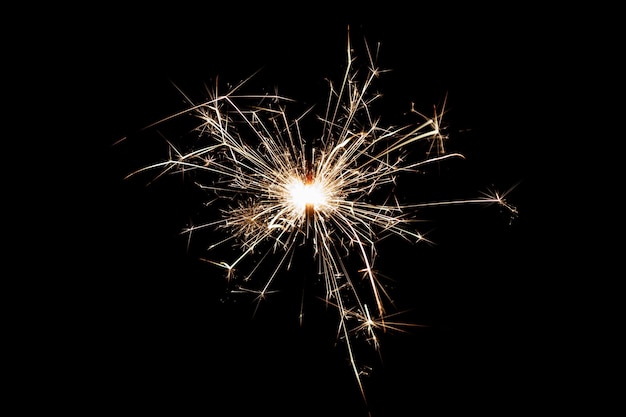 Sparkler in fiamme isolato su sfondo nero Tema fuochi d'artificio Effetto luce e consistenza