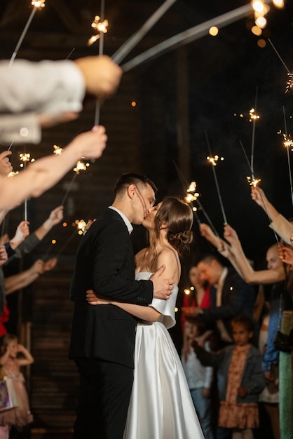 Sparklers al matrimonio degli sposi nelle mani di ospiti gioiosi