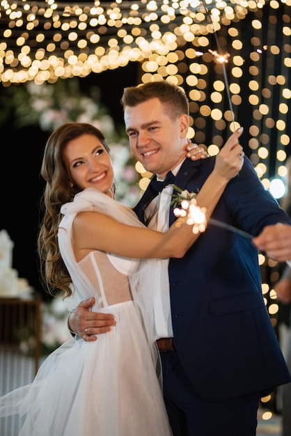 Sparklers al matrimonio degli sposi nelle mani di ospiti gioiosi