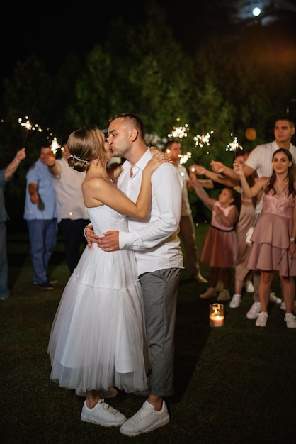 Sparklers al matrimonio degli sposi nelle mani di ospiti gioiosi