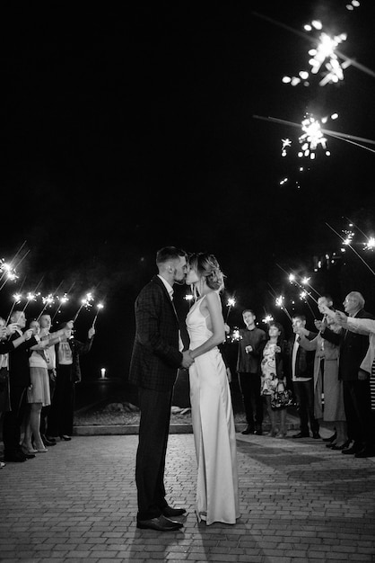 Sparklers al matrimonio degli sposi nelle mani di ospiti gioiosi