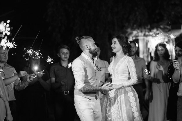 Sparklers al matrimonio degli sposi nelle mani di ospiti gioiosi