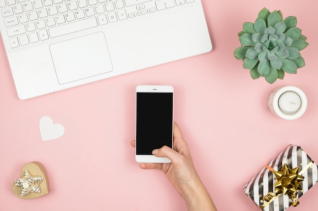 Spazio di lavoro a casa delle donne. Girl Blogger funziona con telefono e laptop. Concetto freelance. Telelavoratore che manda un sms usando laptop e Internet, lavorando online.