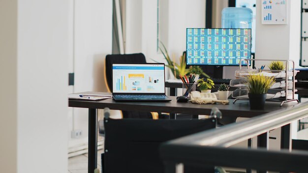 Spazio di lavoro aziendale senza nessuno dentro e figure aziendali sui monitor del computer