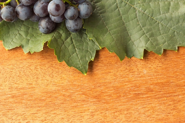 Spazio vuoto su fondo in legno con foglia e uva fresca