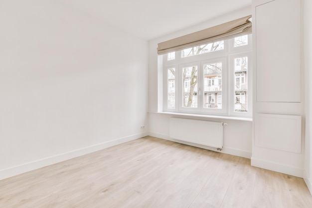 Spaziosa camera vuota e luminosa con pavimento in parquet e ampie finestre in una casa moderna