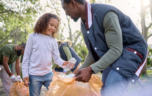 Spazzatura volontario uomo e bambino che pulisce l'inquinamento dei rifiuti o il prodotto di scarto per il supporto ambientale della comunità Contenitore per bottiglie di plastica Beneficenza delle ONG e parco naturale ripulito da un ragazzo nero ecologico