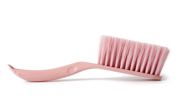Spazzola di plastica rosa per la pulizia della casa isolata su un fondo bianco