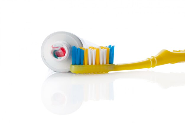 Spazzola e tubo dentali con pasta isolata su bianco